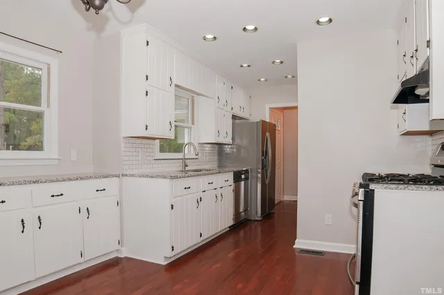 a kitchen with stainless steel appliances a stove a sink a refrigerator and cabinets