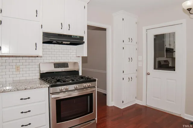 a kitchen with granite countertop white cabinets and sink