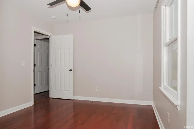 a view of a small space with wooden floor and a window