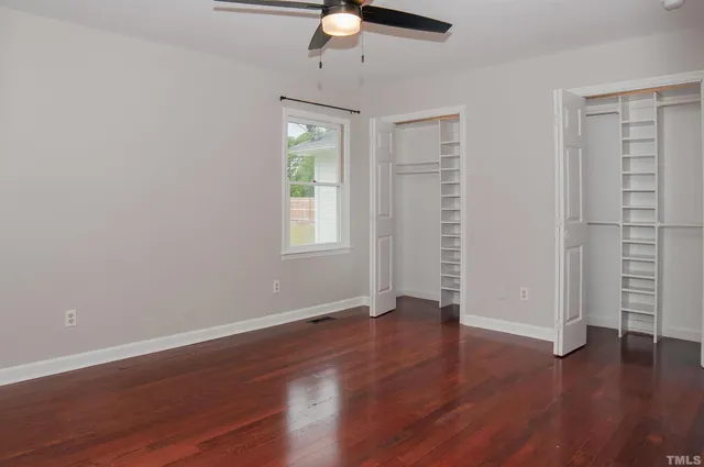 a view of an empty room with wooden floor