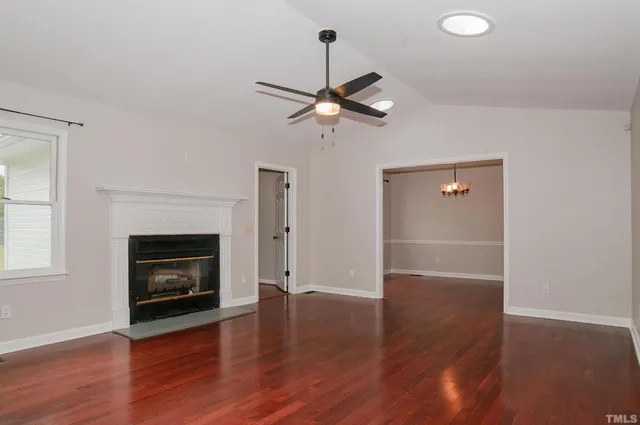 a view of empty room with wooden floor
