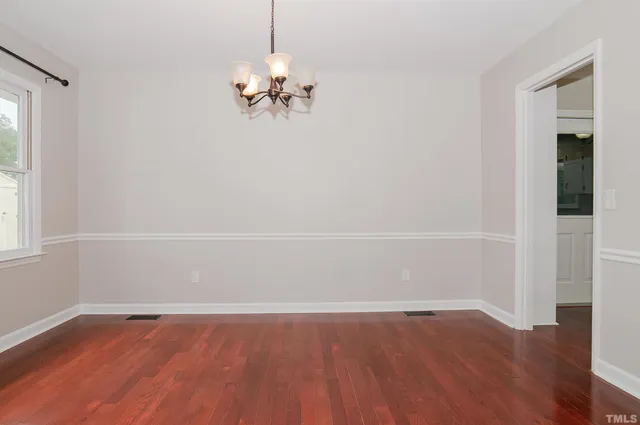 a view of a livingroom with a fireplace a ceiling fan and wooden floor