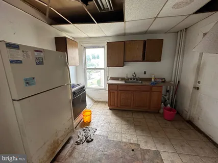 a kitchen with stainless steel appliances a refrigerator sink and wooden cabinets