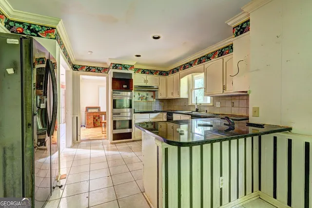 a kitchen with stainless steel appliances granite countertop a stove a sink and a refrigerator