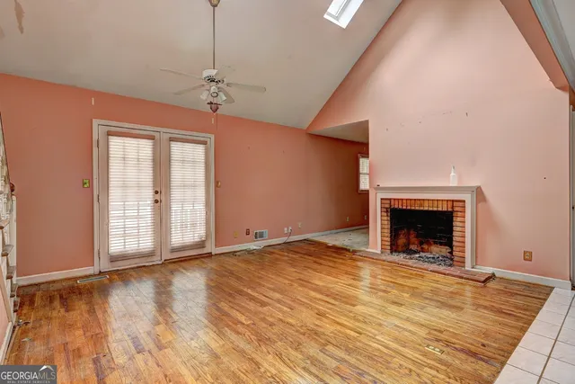 a view of an empty room with a window and fireplace