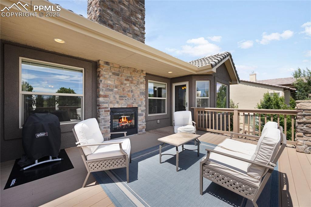 1131 Old North Gate Road Colorado Springs, CO 80921 - Photo 14 of 39 Wooden terrace with an outdoor living space with a fireplace overlooking golf course