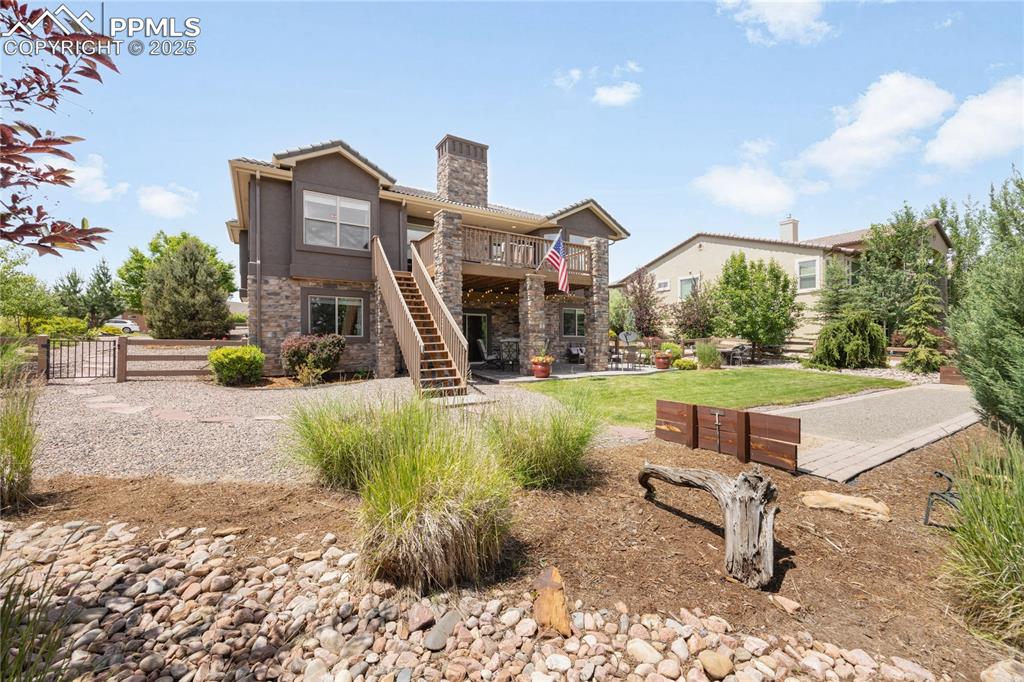 1131 Old North Gate Road Colorado Springs, CO 80921 - Photo 33 of 39 Rear view of property featuring a chimney, stone siding, stairway, a deck, and a patio and several sitting areas for entertaining
