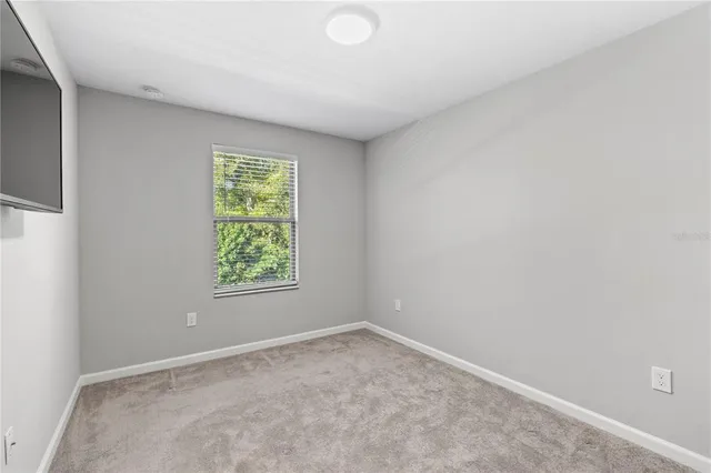 an empty room with closet and a window