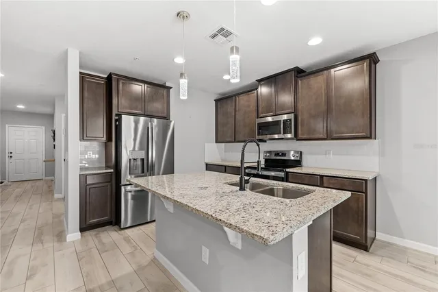 a kitchen with stainless steel appliances granite countertop a sink refrigerator and microwave