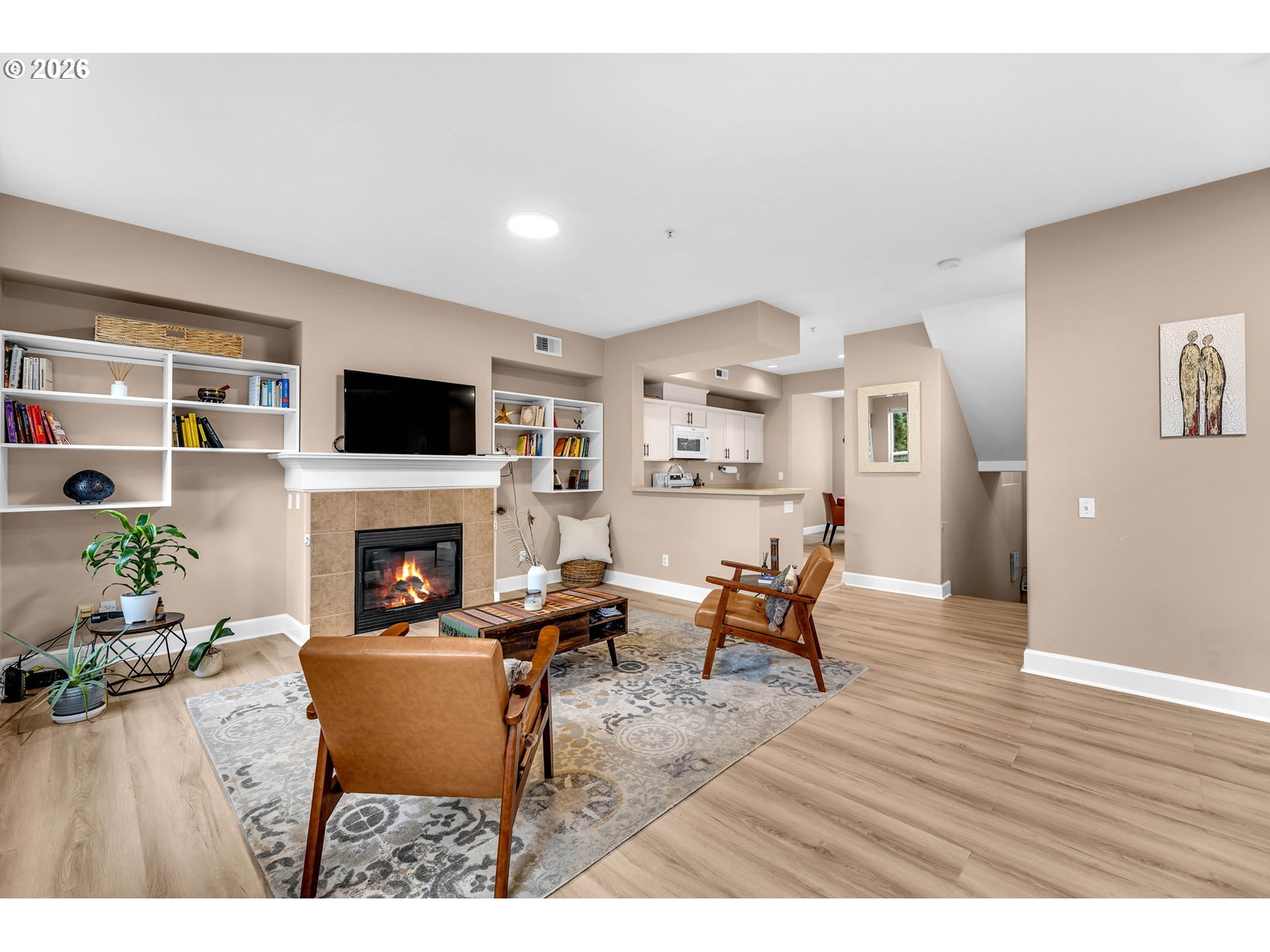 2974 Northwest Kennedy Court, Unit 1 Portland, OR 97229 - Photo 9 of 37 a living room with furniture a fireplace and a flat screen tv