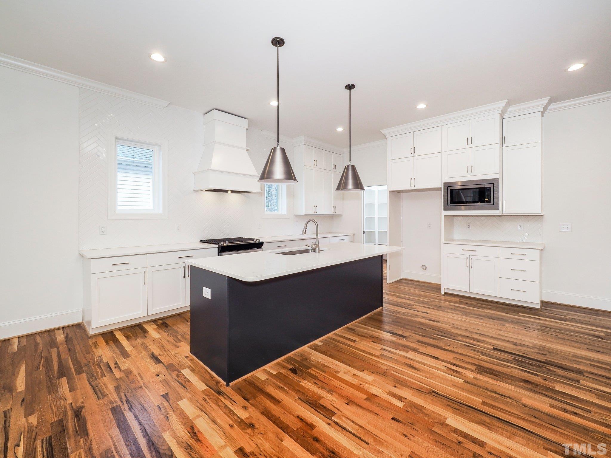 1210 Kent Road Raleigh, NC 27606 - Photo 12 of 30 a kitchen with stainless steel appliances granite countertop a sink stove and wooden floor