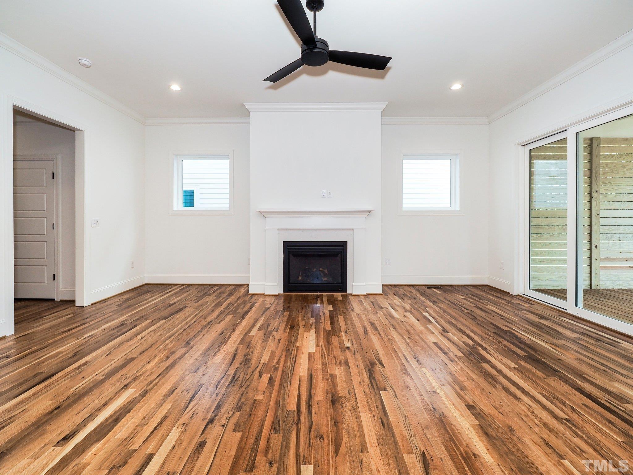 1210 Kent Road Raleigh, NC 27606 - Photo 16 of 30 a view of an empty room with wooden floor fireplace and a window