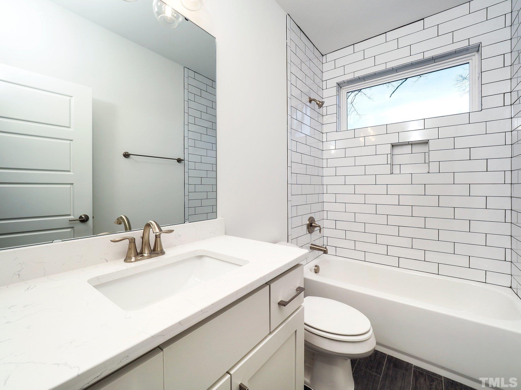 1210 Kent Road Raleigh, NC 27606 - Photo 21 of 30 a bathroom with a sink a toilet and shower