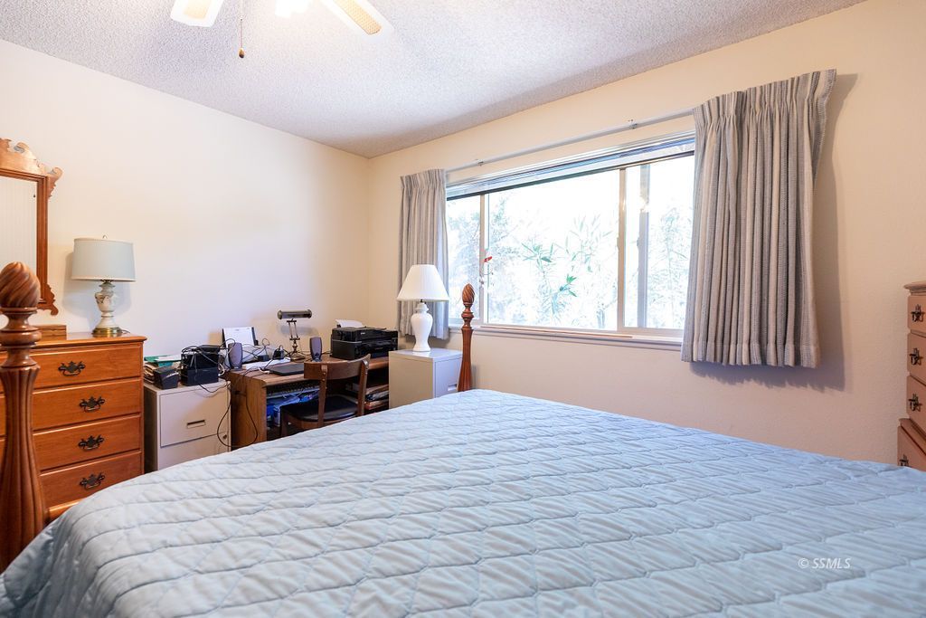 831 Peg Street Ridgecrest, CA 93555 - Photo 14 of 32 a bedroom with a large bed and a large window