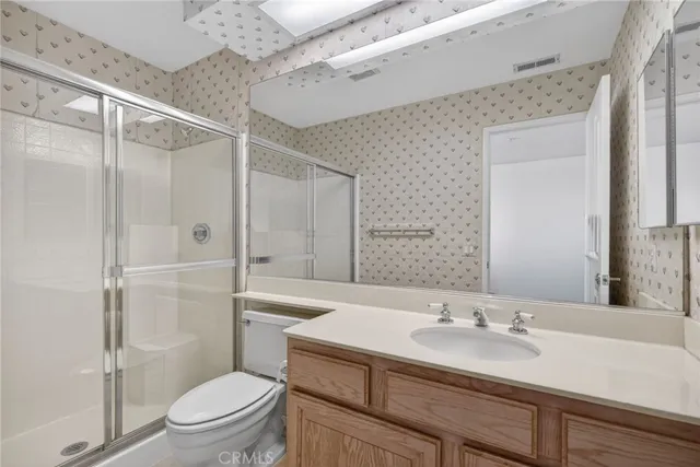 a bathroom with a sink toilet vanity and shower