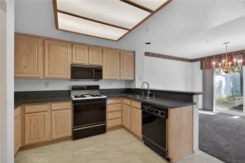 a kitchen with granite countertop a stove sink and cabinets