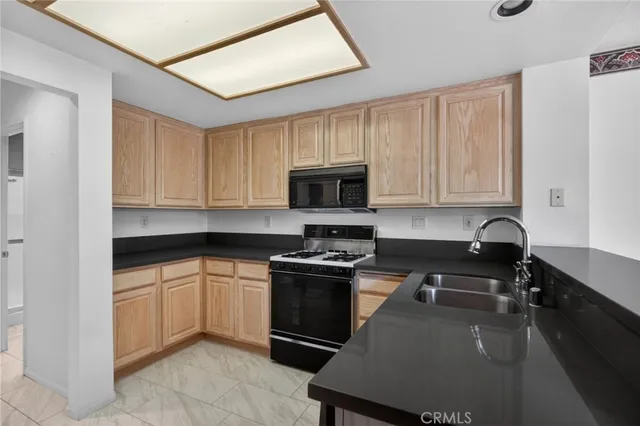 a kitchen with granite countertop a stove sink and cabinets
