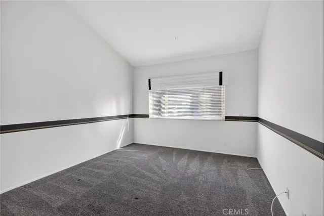 a view of an empty room with wooden floor and windows
