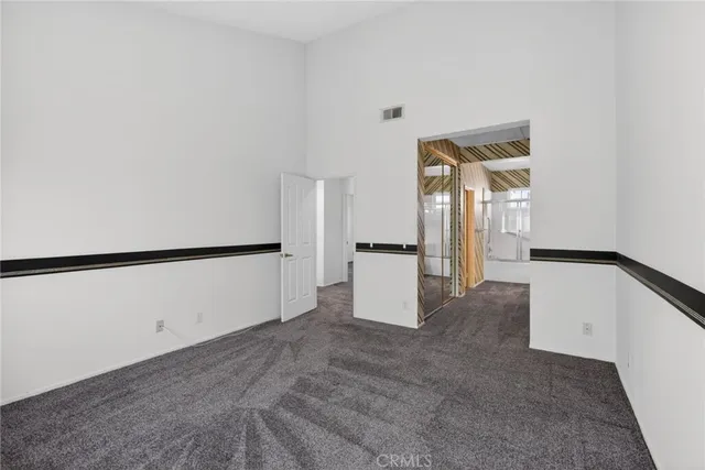 a view of a kitchen with refrigerator and white cabinets