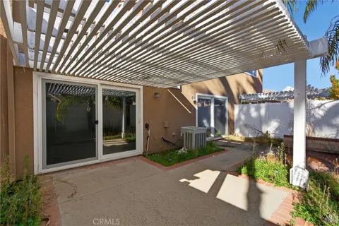 a patio with table and chairs and potted plants