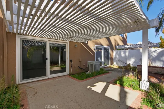 a patio with table and chairs and potted plants