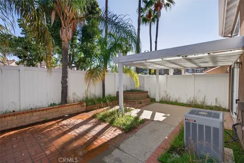 a backyard of a house with table and chairs under an umbrella