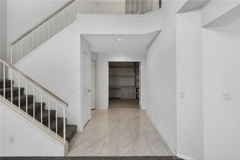 a view of a hallway with an entryway and staircase