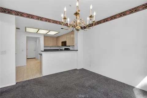 a view of a kitchen with a sink and chandelier