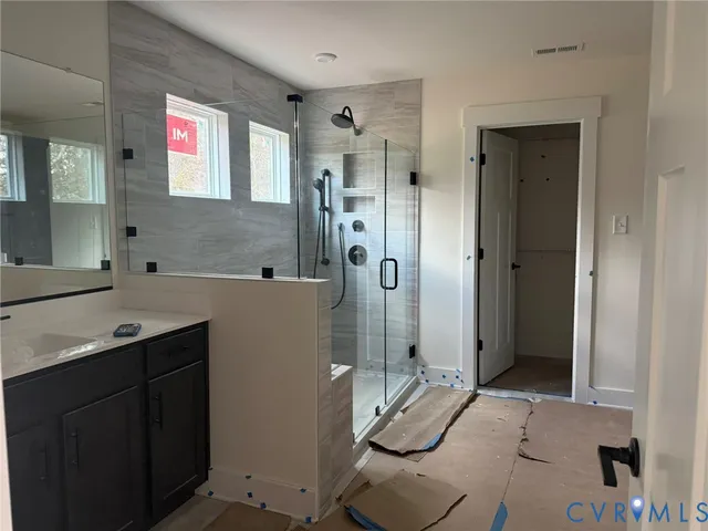 a bathroom with a sink mirror and shower