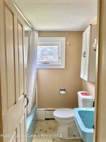 a white toilet sitting next to a bathroom sink and tub