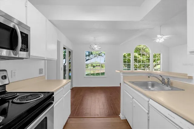 a kitchen with stainless steel appliances granite countertop a sink stove and cabinets