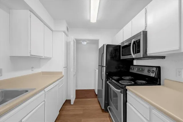 a kitchen with stainless steel appliances a stove microwave and refrigerator