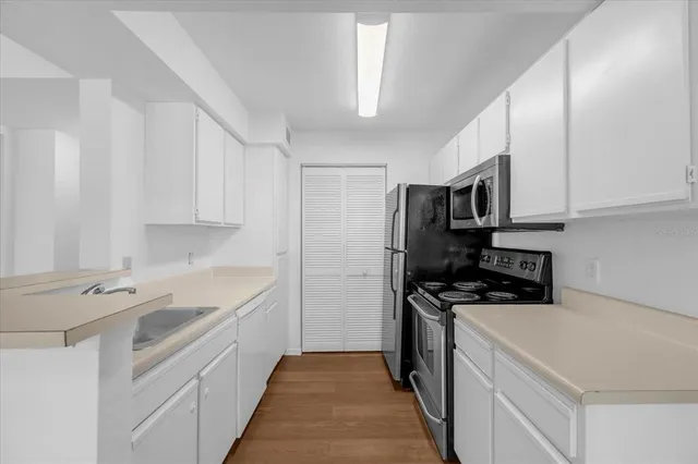 a kitchen with stainless steel appliances a stove sink microwave and cabinets