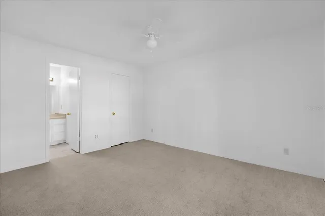 an empty room with fan and entrance