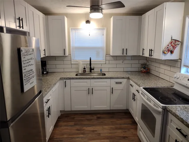 a kitchen with stainless steel appliances granite countertop a sink stove and refrigerator