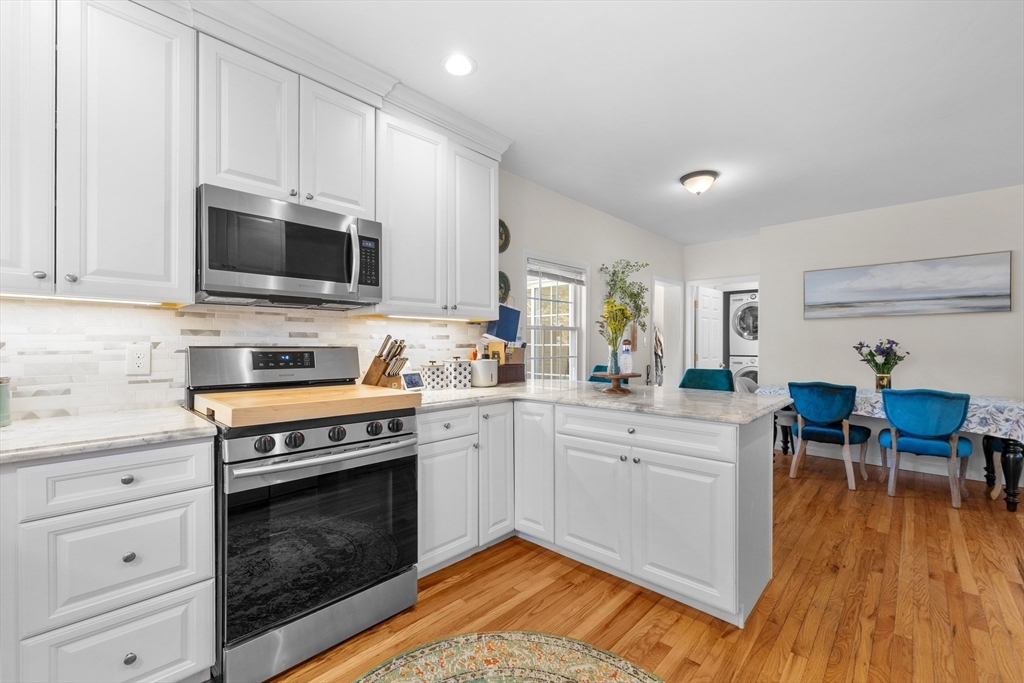 38 Brook Street Georgetown, MA 01833 - Photo 10 of 42 a kitchen with stainless steel appliances a stove a sink dishwasher and a microwave oven with wooden floor