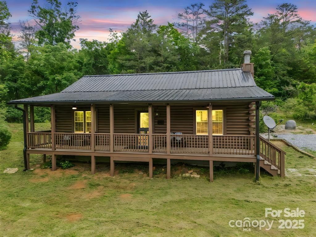 a backyard of a house with large trees and wooden fence