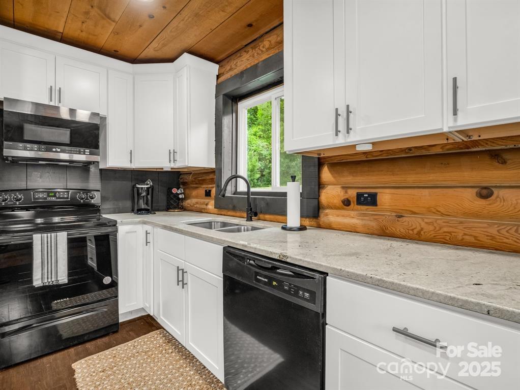 112 Bills Creek Road Lake Lure, NC 28746 - Photo 15 of 42 a kitchen with stainless steel appliances granite countertop a stove a sink and a microwave