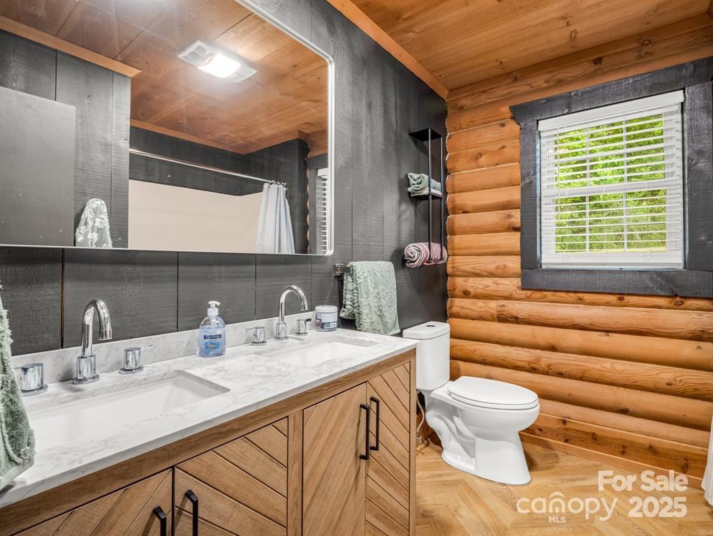 112 Bills Creek Road Lake Lure, NC 28746 - Photo 20 of 42 a bathroom with a granite countertop sink and a mirror