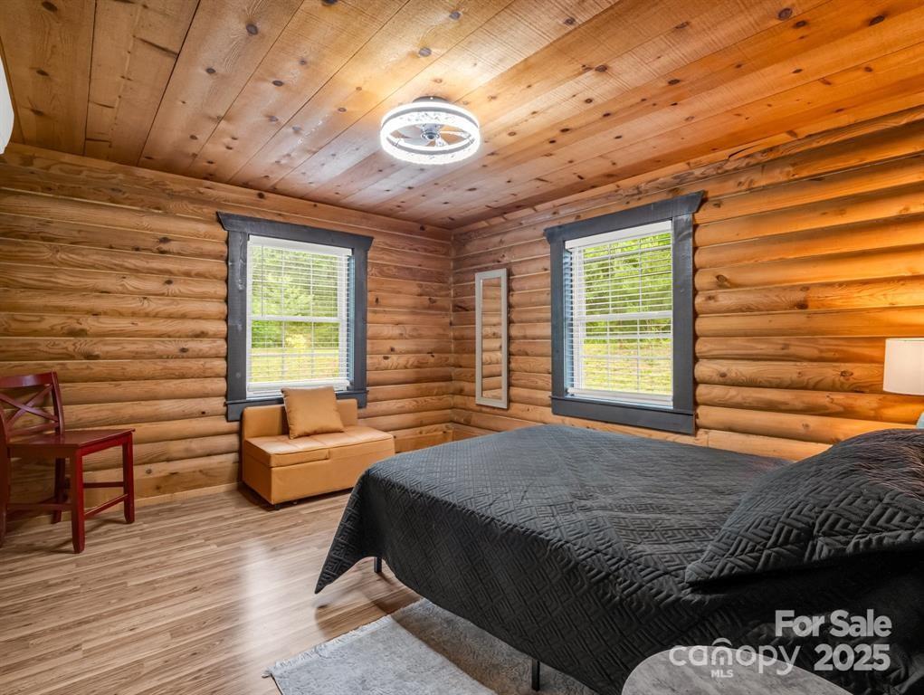112 Bills Creek Road Lake Lure, NC 28746 - Photo 23 of 42 a bedroom with a bed and wooden floor