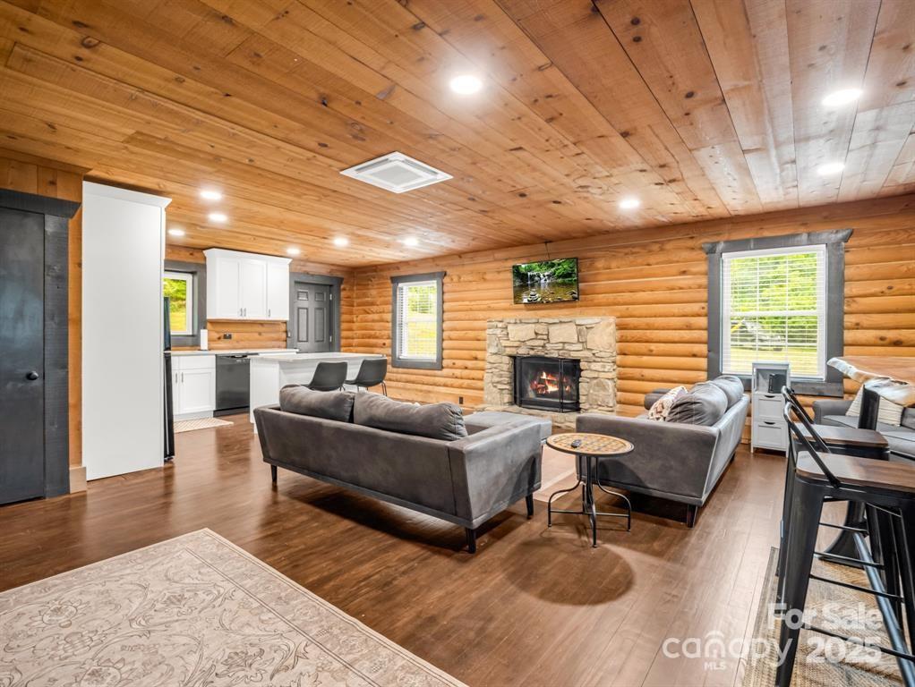 112 Bills Creek Road Lake Lure, NC 28746 - Photo 6 of 42 a living room with furniture a fireplace wooden floor and a rug