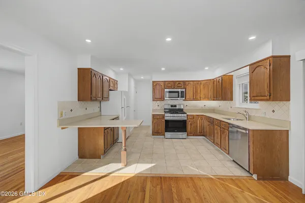 a large kitchen with stainless steel appliances a sink and cabinets