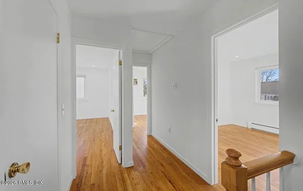 a view of a hallway with wooden floor and staircase