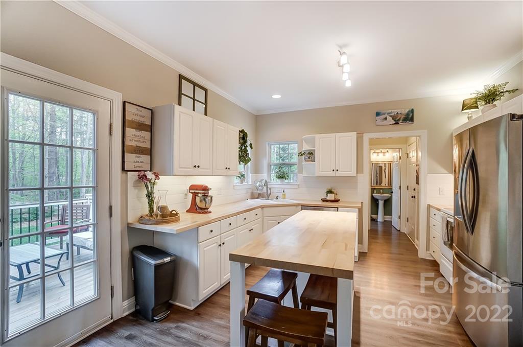 917 Potter Road Monroe, NC 28110 - Photo 7 of 25 a kitchen with stainless steel appliances granite countertop a refrigerator a sink a stove and white cabinets with wooden floor