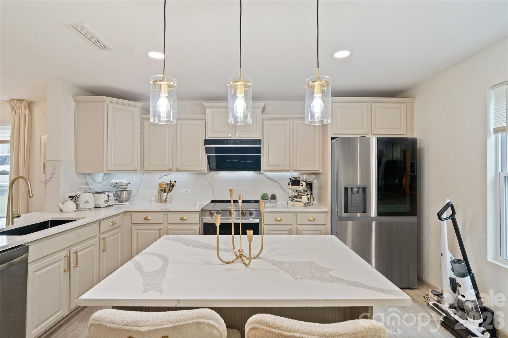 8726 Conrad Street Locust, NC 28097 - Photo 11 of 36 a kitchen with stainless steel appliances kitchen island granite countertop a refrigerator a sink a stove and white cabinets