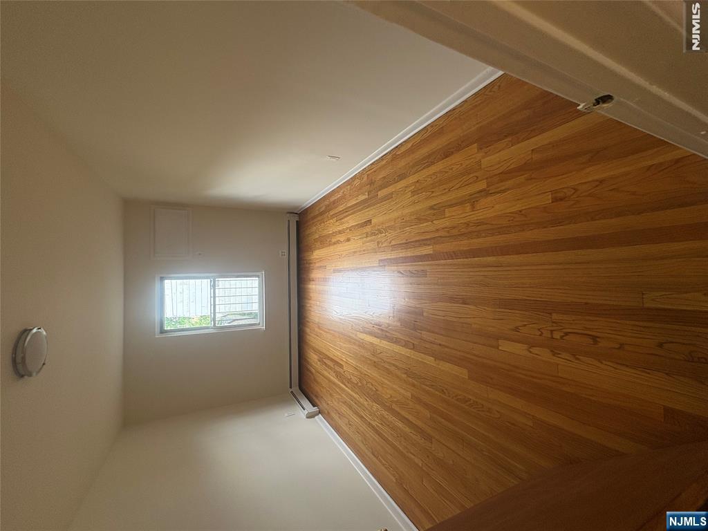399 Walker Street, Unit 1B Fairview, NJ 07022 - Photo 7 of 11 wooden floor in an empty room with a window