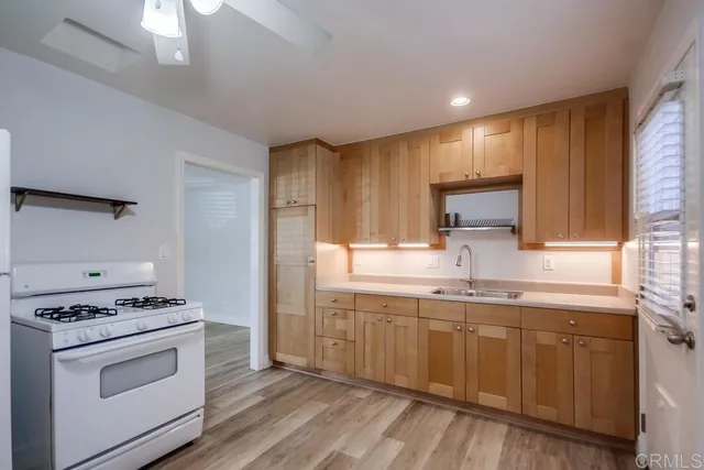 a kitchen with a sink stove top oven and cabinets