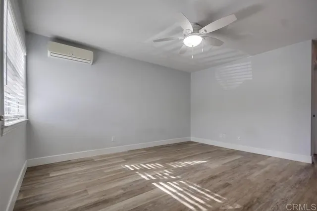 a view of a room with wooden floor and a ceiling fan