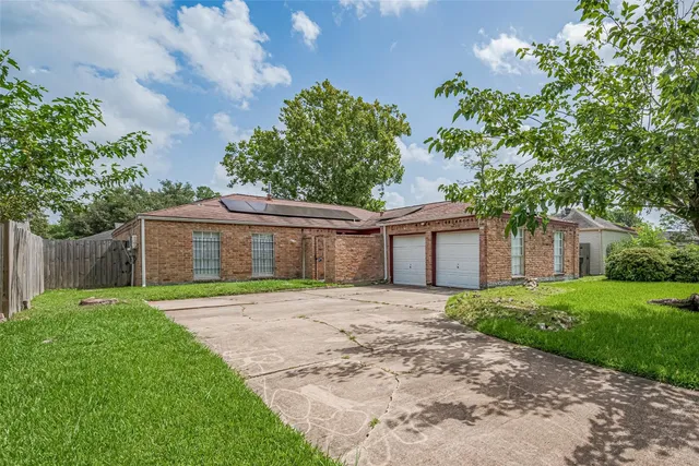 a front view of a house with a yard and trees