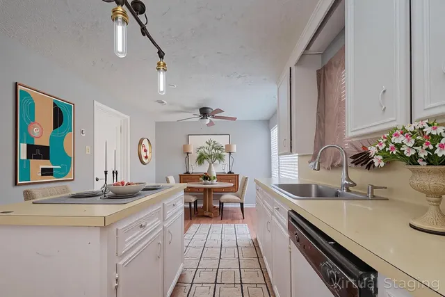 a kitchen with stainless steel appliances a stove a sink and white cabinets